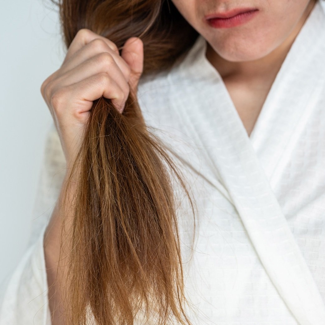 Woman holding strand of split ends